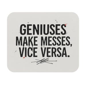 May include: A rectangular mouse pad with a light gray background featuring the black text GENIUSES MAKE MESSES, VICE VERSA. The lettering has a distressed, dripping paint effect with small black and red splatters and a signature-like scribble.