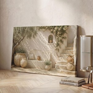 Può includere: Una stampa su tela rettangolare che raffigura un cortile mediterraneo con una panca in pietra, vasi in terracotta, un ulivo e una scala in pietra. L'opera presenta calde tonalità beige e crema con piante rampicanti e ombre soffuse.