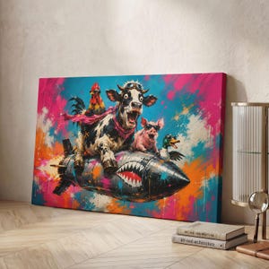 May include: A rectangular canvas print featuring a black and white cow, a rooster, a pig, and a duck wearing goggles while riding a dark gray missile with a shark mouth graphic. The background is a vibrant, abstract splash of pink, blue, and orange.