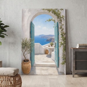 Könnte beinhalten: Ein rechteckiger Wandkunstdruck, der eine offene Bogentür mit hellblauen Türen zeigt, die den Blick auf das Mittelmeer und Klippen freigibt. Ein Olivenbaum im Topf steht links und weiße blühende Ranken klettern am steinernen Torbogen empor.