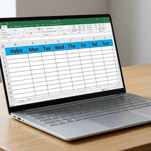 May include: A silver laptop displaying a digital habit tracker spreadsheet on its screen. The spreadsheet features a blue header row with the labels Habit, Mon, Tue, Wed, Thu, Fri, Sat, and Sun, followed by eleven numbered rows for tracking.