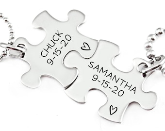 May include: Two silver puzzle pieces on a chain necklace. The pieces are engraved with the names "Chuck" and "Samantha" and the date "9-15-20".