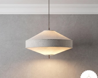 May include: A pendant light fixture featuring a wide, double-conical fabric shade in a light gray textured material. The lamp is suspended by a thin, dark brown metal rod from a matching circular ceiling canopy and includes a small metal finial.