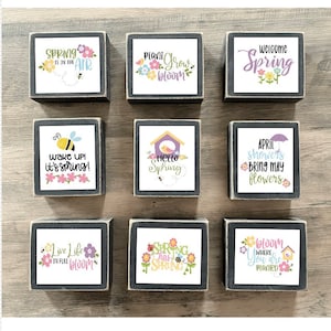 May include: Nine wooden signs with spring-themed designs. The signs feature phrases like "Spring is in the air", "Plant Grow Bloom", "Welcome Spring", "Wake Up! It's Spring!" and "Hello Spring".