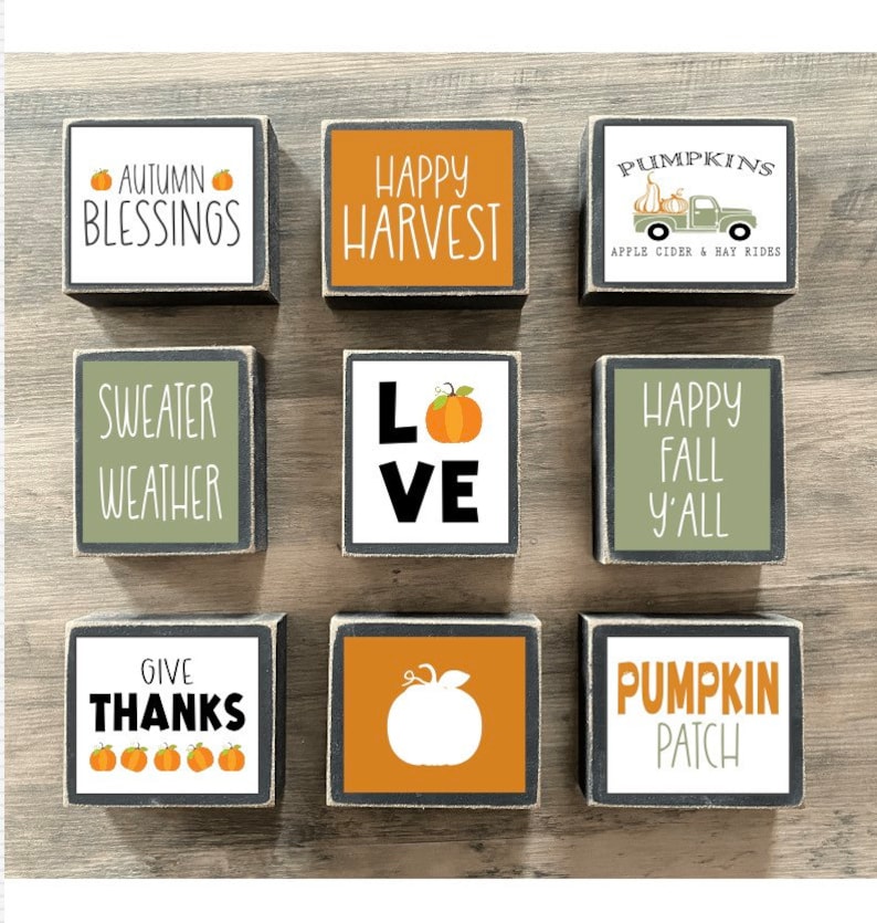 Może przedstawiać: Dziewięć drewnianych klock&oacute;w z jesiennymi wzorami i napisami. Klocki zawierają frazy takie jak "Autumn Blessings", "Happy Harvest", "Sweater Weather", "Love", "Happy Fall Y'all", "Give Thanks", "Pumpkins Apple Cider & Hay Rides", "Pumpkin Patch".