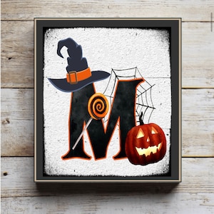 May include: A black and orange Halloween-themed letter M with a witch's hat, a lollipop, and a jack-o'-lantern.