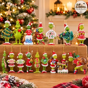 Puede incluir: Una colección de adornos navideños del personaje Grinch verde en varias poses, incluyendo con gorros de Santa, sosteniendo regalos, cargando árboles de Navidad y usando suéteres festivos, cada uno con un lazo dorado para colgar.