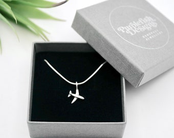 May include: A silver airplane necklace in a gray box with a black interior. The box has the text "Purplefish Designs" printed on the top.