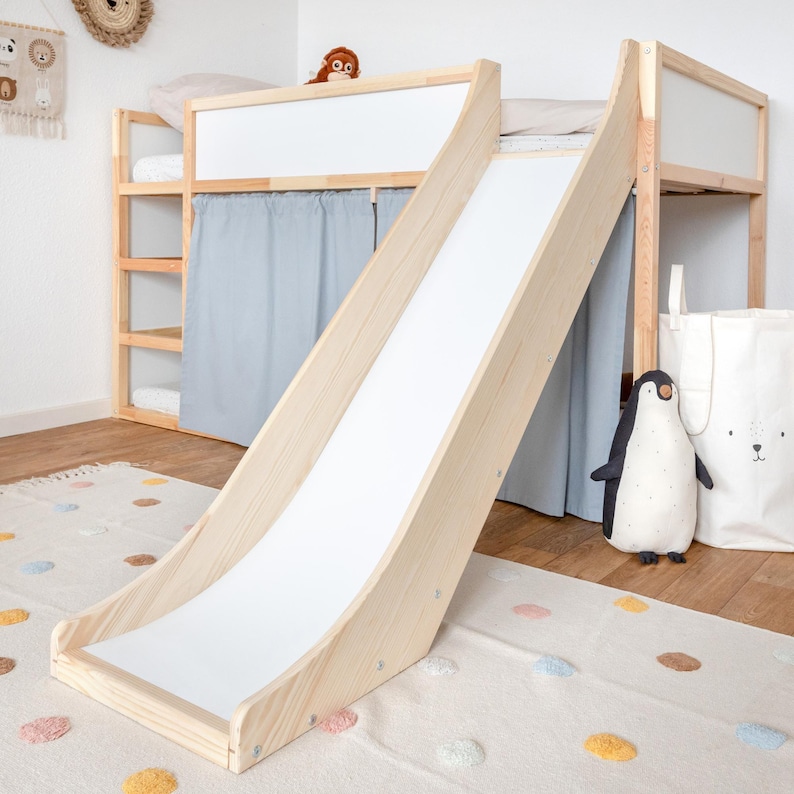 Eine Indoor Rutsche für das Hochbett Kura von IKEA. Das Kinderbett wurde zudem mit hellblauen Vorhängen verschönert.