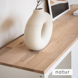 Nahansicht von einer naturbelassenen Holzplatte für ein Ikea Kallax Regal. Auf dem Holz steht eine Vase.
