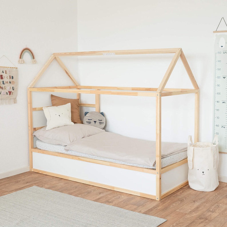 Ein Kinderzimmer, in dem man das Kura Bett von Ikea sieht. Im Bett liegen Kissen und eine Bettdecke.