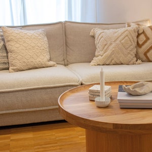 Eine beige Couch wurde mit 4 Boho Kissen dekoriert.