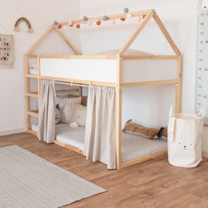 Ein Kinderzimmer, in dem man das Kura Bett von Ikea umfänglich mit Kuscheltieren und anderen Textilien dekoriert sieht.