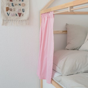 Detailansicht einer Vorhangstange samt pinkem Vorhang an einem Kura Bett von Ikea.