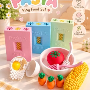 May include: A play food set featuring three rectangular boxes labelled PASTA Play Food Set and Rotini in pink, blue, and light green. Includes a white bowl with a red tomato, pink and white pasta pieces, three small orange carrots, a yellow corn cob, and a white egg with a yellow yolk.