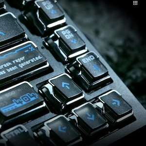 May include: A black mechanical keyboard with glossy keycaps featuring blue backlit symbols and text. Visible keys include PG UP, PG DN, END, arrow keys, and custom keys displaying the text "crash repor has been generated" and "404".