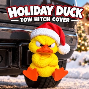 May include: A yellow duck tow hitch cover wearing a red and white Santa hat with a grumpy expression and crossed arms. The text HOLIDAY DUCK TOW HITCH COVER is displayed in bold white letters with a red outline above the duck figure.