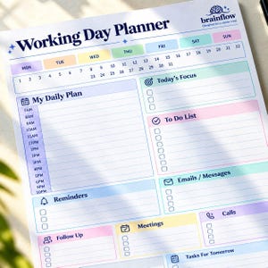 May include: A white paper Working Day Planner with colorful pastel sections. It features a calendar header, a daily schedule from 7AM to 10PM, and categorized boxes for Today's Focus, To Do List, Emails, Messages, Reminders, Calls, Meetings, Follow Up, and Tasks For Tomorrow.