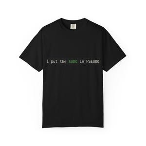 May include: A black short-sleeved t-shirt featuring the white text 'I put the' followed by the green text 'SUDO' and the white text 'in PSEUDO' printed across the center of the chest. The shirt has a standard crew neckline and a casual fit.