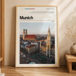 Peut inclure: Une affiche encadrée présentant une photographie du paysage urbain de Munich, incluant la Frauenkirche et le nouvel hôtel de ville. Le poster affiche le texte Munich, Germany, les coordonnées 48.1374 N 11.5755 E et un texte descriptif.