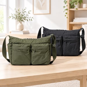 May include: Two rectangular crossbody bags made of a soft, lightweight material. One bag is olive green and the other is black. Each bag features a main zippered compartment, two large front zippered pockets, and an adjustable shoulder strap.