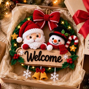 May include: A crocheted Christmas wreath featuring a Santa Claus and a snowman, a large red bow, and a wooden sign with the text Welcome. The wreath is decorated with small lights, holly berries, and two yellow bells hanging from the bottom.