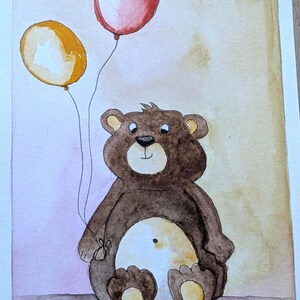 May include: A watercolor painting of a brown teddy bear with a cream-colored belly, sitting upright and holding two balloons. One balloon is red and the other is yellow. The bear has dark brown fur, a black nose, and a small dot on its belly.