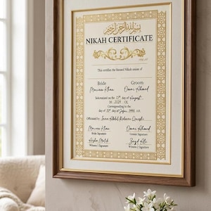 Può includere: Un certificato di Nikah incorniciato con bordi decorativi dorati e calligrafia araba nella parte superiore. Il documento include campi per i nomi degli sposi, la data e le firme, stampato su carta color crema all'interno di una cornice in legno scuro.