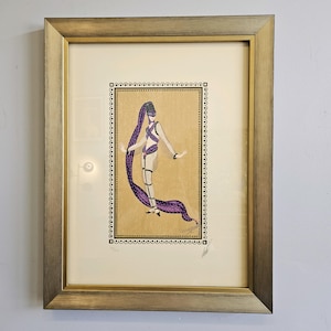 May include: A framed print of a woman in a purple and white costume with a purple scarf. The print is surrounded by a gold frame.