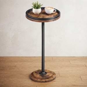 May include: A tall, round side table featuring a dark wood-grain tabletop with a black metal rim, supported by a single black metal pole attached to a circular, tiered wood-grain base. A small potted green plant and a white coffee mug sit on top.