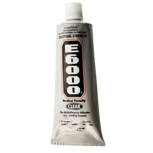 May include: A tube of E6000 clear multi-purpose adhesive. The silver tube has a white cap and features the text "INDUSTRIAL STRENGTH" and "CLEAR". The tube contains 110 ml of adhesive.