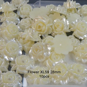 May include: A collection of 10 white pearl-like flower embellishments. Each flower is approximately 28mm in diameter. The flowers are arranged in a random pattern on a white surface. Flower XL59 28mm 10pcs.
