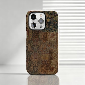 Puede incluir: Una funda para smartphone con un diseño de patchwork de varios paneles con intrincados patrones florales y de damasco en tonos marrón oscuro, naranja óxido, oro apagado y azul marino profundo. La funda tiene un recorte para una cámara triple.