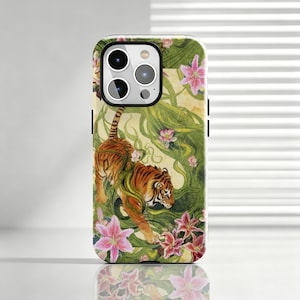 Pode incluir: Uma capa de smartphone com uma ilustração em aguarela de um tigre laranja e preto a caminhar por um ambiente de selva verdejante, repleto de flores de lírio cor-de-rosa vibrantes e longas vinhas verdes sobre um fundo amarelo pálido.