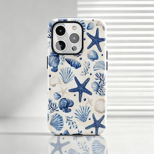 May include: A smartphone case featuring a repeating pattern of dark blue starfish, various seashells, and coral-like seaweed illustrations set against a light cream-colored background. The case has a cutout for a triple-lens camera system.