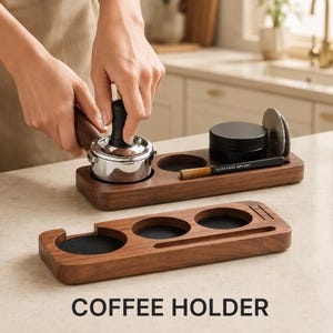 Puede incluir: Un organizador rectangular de accesorios para café en madera oscura con aberturas circulares con inserciones negras texturizadas, una ranura para cepillo de limpieza y una ranura vertical. El texto COFFEE HOLDER aparece debajo de los organizadores.