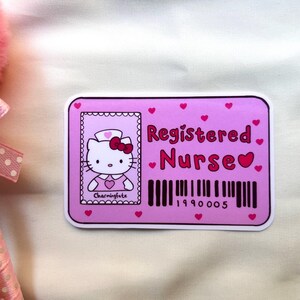Puede incluir: Pegatina rosa y blanca con un personaje de dibujos animados de Hello Kitty con un uniforme de enfermera. La pegatina dice "Registered Nurse" con un s&iacute;mbolo de coraz&oacute;n y un c&oacute;digo de barras con el n&uacute;mero 1990005.