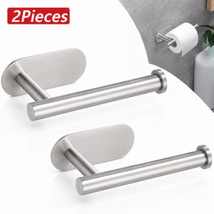 May include: Two pieces of a brushed stainless steel toilet roll holder, each featuring a horizontal cylindrical bar attached to an oval-shaped wall mounting plate. The set includes a visual example of the holder mounted on a wall with paper.