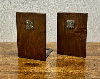 Sujetalibros de madera vintage con emblema de Pegaso, estilo moderno de mediados de siglo, acabado en nogal y bases de metal negro.
