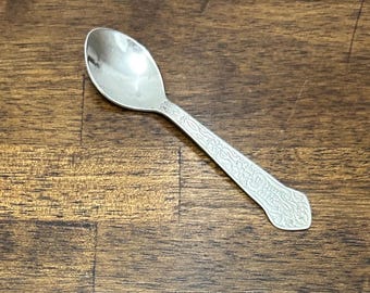 Cuchara de café pequeña vintage bañada en plata, con estampado floral Art Déco y relieve.