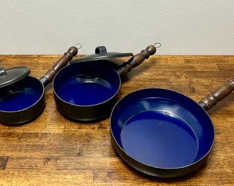 Juego de ollas y sartenes apilables de esmalte escandinavo vintage con interior azul y asas de madera. Incluye 3 sartenes y 2 tapas.