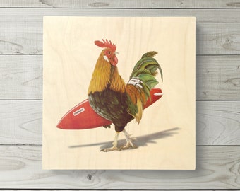 May include: A rooster with a red, green, and yellow plumage is holding a red surfboard with the word "Mahalo" printed on it. The rooster is standing on a light wood background.