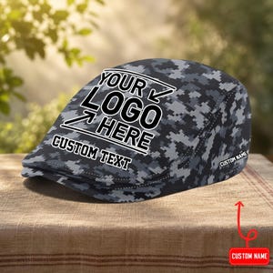 May include: A gray and black digital camouflage flat cap featuring the white text YOUR LOGO HERE with arrows pointing to the center, the words CUSTOM TEXT below, and a small white label on the side with the text CUSTOM NAME.
