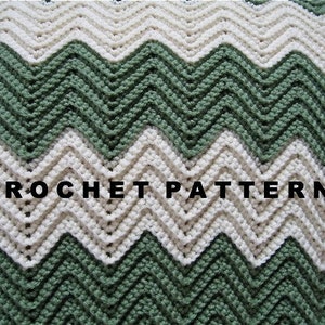 May include: A crochet pattern for a chevron blanket in green and white. The pattern is written out on the blanket.