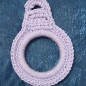 May include: A lavender crocheted ring with a loop at the top. The ring is made with a single crochet stitch and is approximately 4 inches in diameter.
