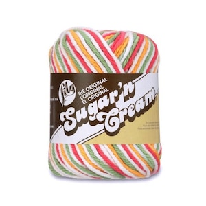 May include: A skein of Lily Sugar'n Cream yarn in a multi-color striped pattern. The yarn features stripes of red, white, green, yellow, and orange. The label reads "THE ORIGINAL Sugar'n Cream".