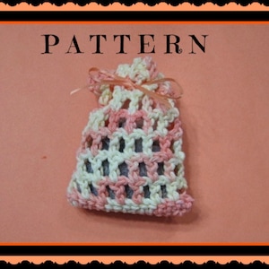 Peut inclure: Un sac à cordon crocheté avec un motif rayé rose et blanc. Le sac est noué avec un ruban rose et le mot "PATTERN" est écrit en lettres noires au-dessus du sac.