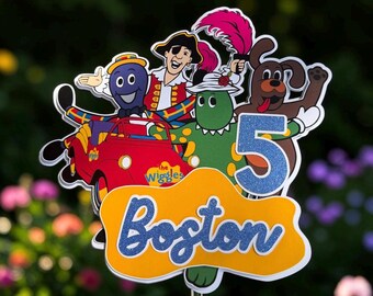 May include: A cake topper featuring The Wiggles characters, including Captain Feathersword, Dorothy the Dinosaur, and Wags the Dog in a red car. It includes a blue glittery number 5 and a yellow sign with the name Boston in blue glittery text.