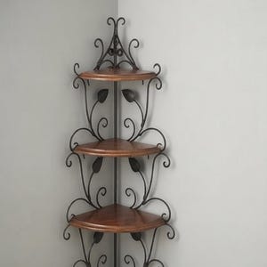 May include: A three-tier corner shelf unit featuring dark brown wooden triangular shelves supported by a black metal frame. The frame is decorated with scrollwork and metal leaf accents, designed to fit flush against a wall corner.