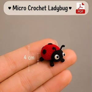 Puede incluir: Una mariquita de micro ganchillo con cuerpo rojo con puntos negros y cabeza negra con ojos blancos y antenas. El texto Micro Crochet Ladybug aparece en la parte superior. Un gráfico de medición indica una altura de 4 cm para el artículo.